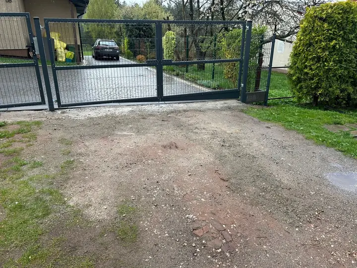 Brama panelowa przy wjeździe do posesji z ogrodem